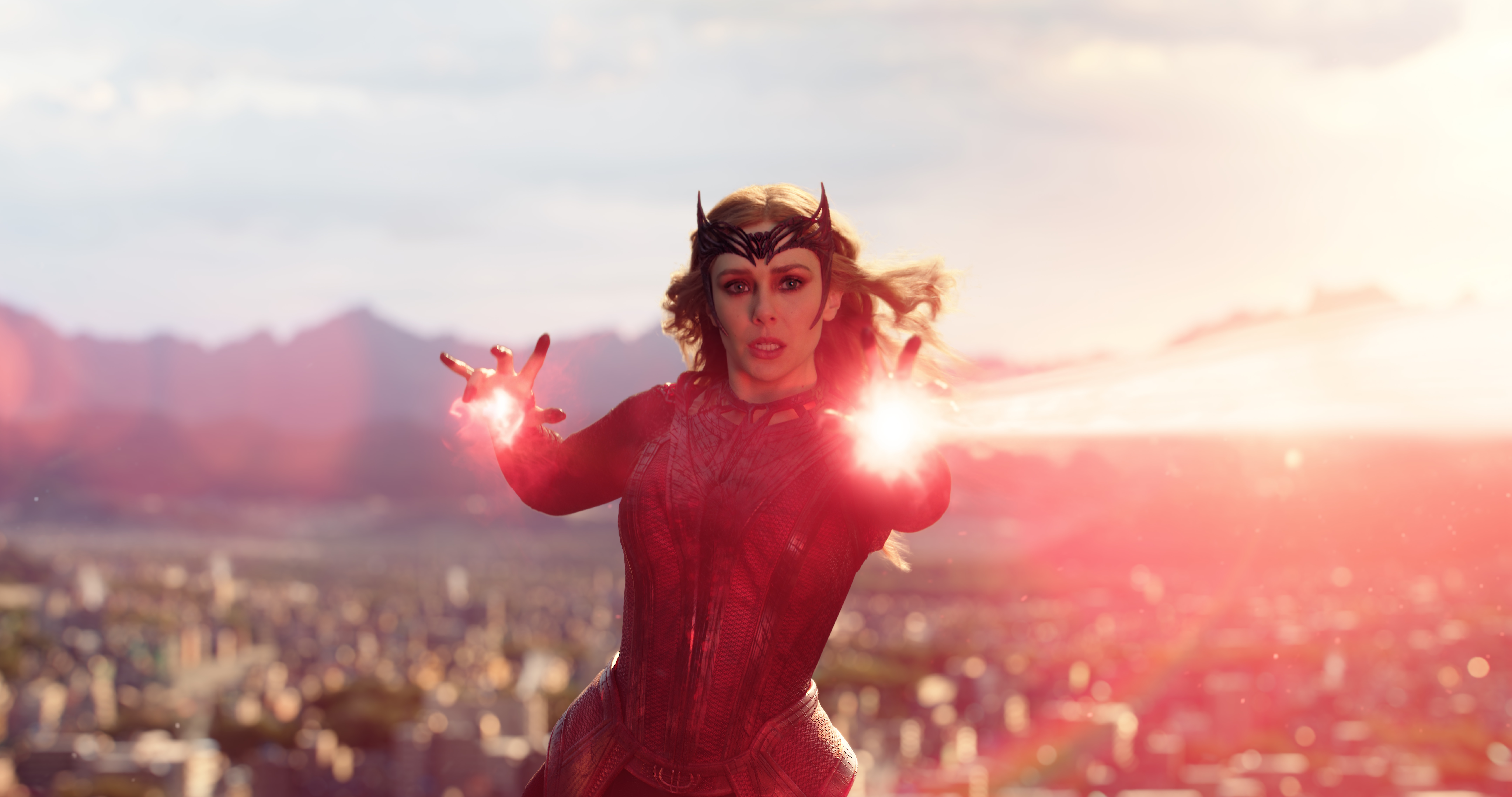 Scarlet Witch shoots a red beam of energy at someone off screen.